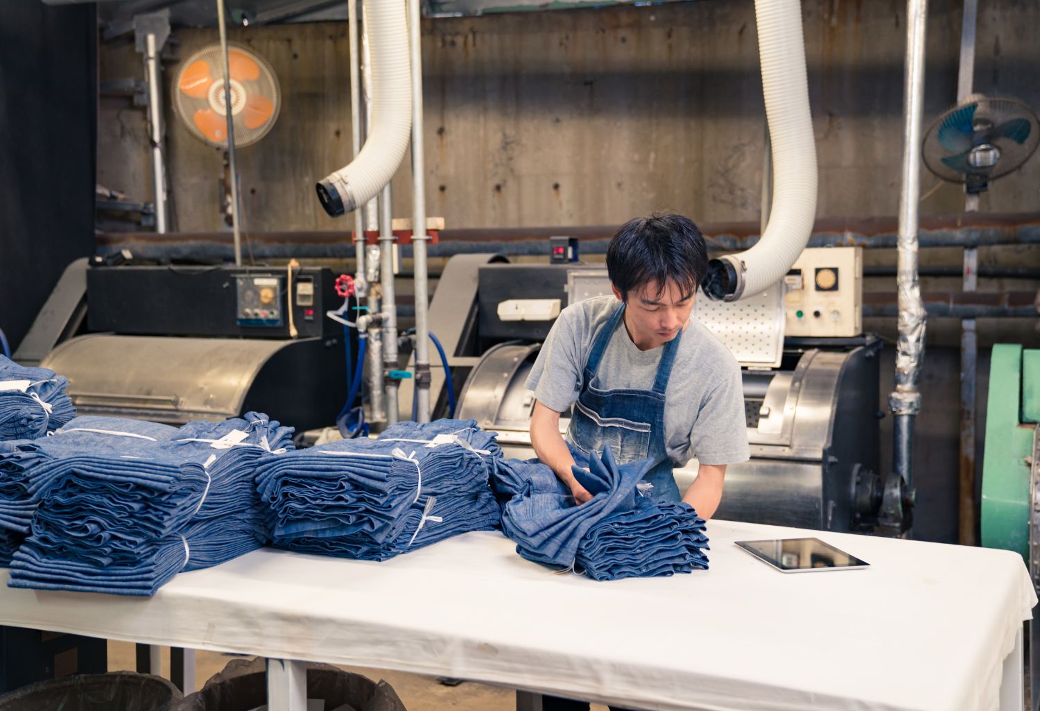 Textiles and Apparel Trade: Malaysian content textile industry worker washing and sorting garments before shipping